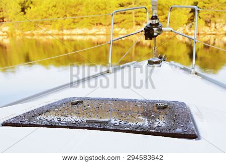 The Twist Of A Staysail On A Sailing Yacht And Bow Rails Against The Backdrop Of A Picturesque Green