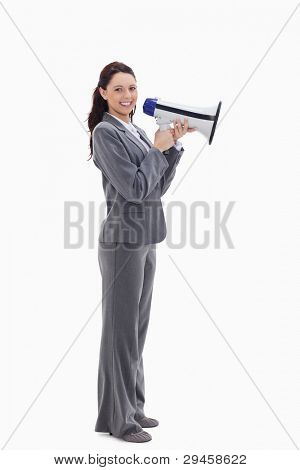 Profile of a businesswoman smiling with a megaphone against white background