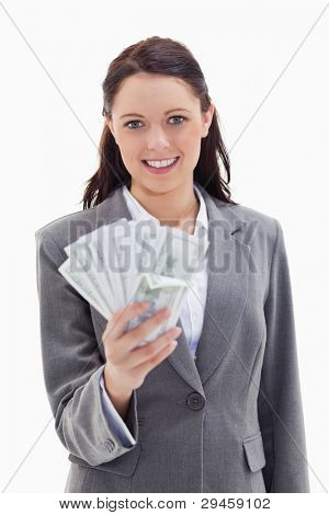 Close-up of a businesswoman smiling and holding a lot of dollar bank notes against white background