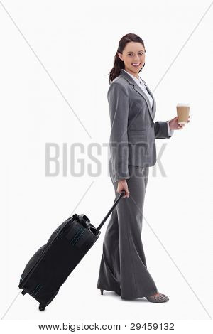 Profile of a businesswoman smiling with a suitcase and holding a coffee against white background