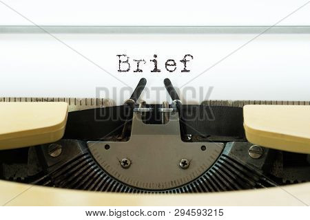 Brief Word Typed On A Yellow Vintage Typewritter. Business Concept.