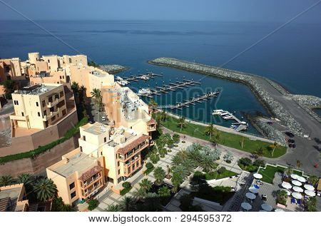 Dibba Al-Fujairah, Fujairah, UAE - April 4, 2019: View from Hotel Fairmont Fujairah beach resort over Mina Al Fajer buildings and pier