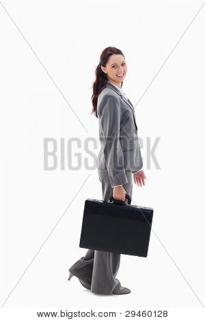 Profile of a business woman smiling and walking with a briefcase against white background