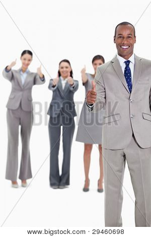 Business team smiling with thumbs up and with one businessman in foreground