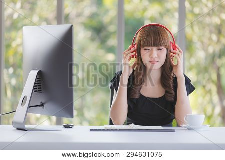 Young Beautiful Asian Office Staff In Black Dress Sitting At Working Desk Enjoy Nice Music With Red 