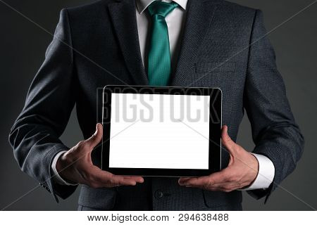 Digital Tablet Computer With A Blank Screen In A Business Man Hands On Gray Background. Special Offe