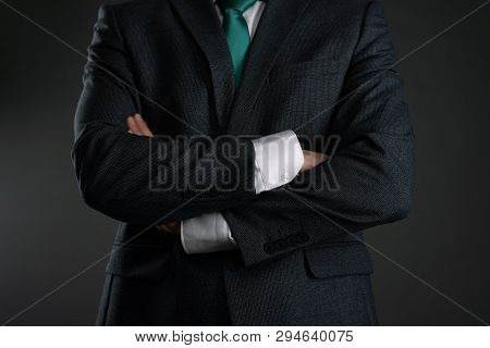 Businessman With A Crossed Hands On A Gray Background. Business Acumen. Strict Boss.
