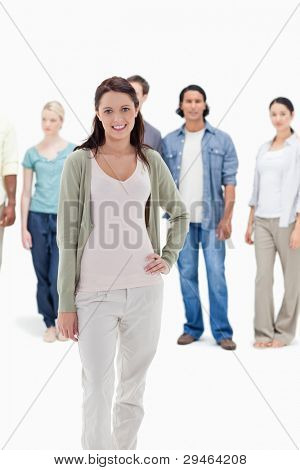 Close-up of people behind a smiling woman with her hand on her hip against white background