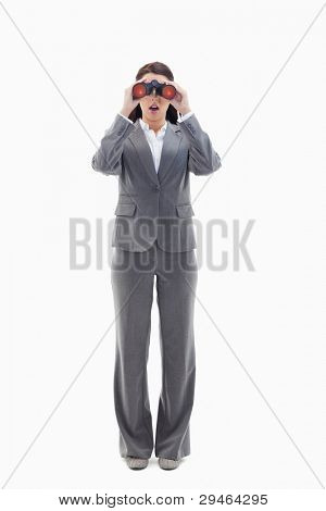 Surprised businesswoman looking through binoculars against white background