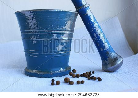Black Peppercorns And Allspice In Ancient Metal Mortar With Pestle On Linen Background