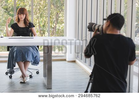 Photographer And Stylist Team Working On Studio Portrait Of Young Beautiful Asian Woman With Dark Br