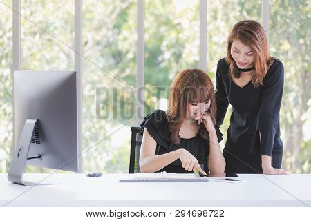 Portrait Of Two Beautiful Asian Successful Businesswomen In Black Dresses Busily Working In Modern O