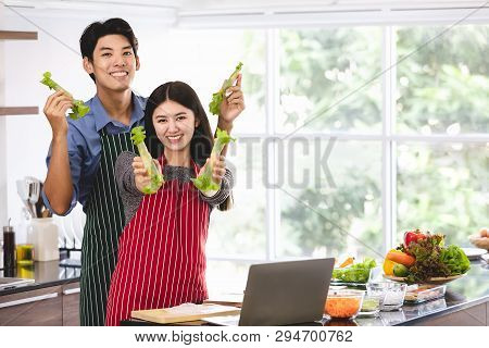 Couple In Apron Make Salad Rolls Together..