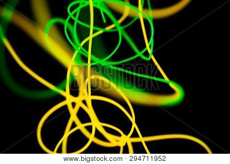 Yellow Neon And Green Neon Abstract. Neon Lines. Isolated On Black Background.