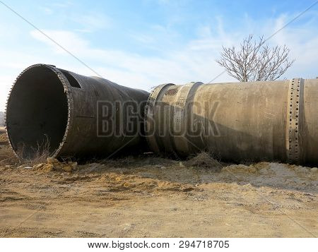 Old Rye Pipes Of Large Diameter Lie On The Ground. Pipeline. Large Iron Drainage Pipes Connect Two R