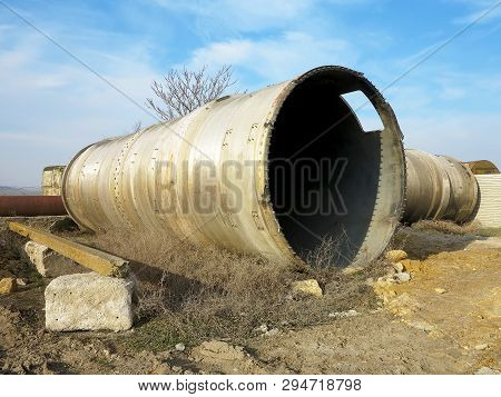 Old Rye Pipes Of Large Diameter Lie On The Ground. Pipeline. Large Iron Drainage Pipes Connect Two R