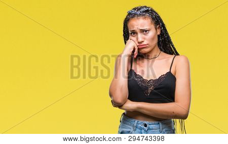Young braided hair african american with pigmentation blemish birth mark over isolated background looking stressed and nervous with hands on mouth biting nails. Anxiety problem.
