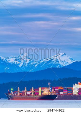 freighters stop at the bay of vancouver at sunset.