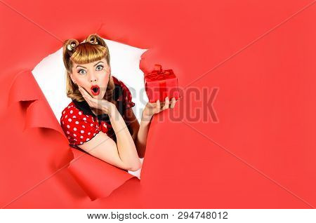 Amazed Girl With Gift Breaking Paper. Surprised Retro Woman Hold Gift Box Through Hole In Paper. Wom