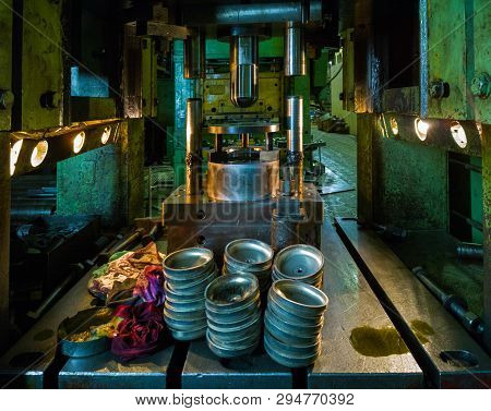 Dirty Used Low Tech Stamping Press Producing Round Aliminium Parts In Dark Environment