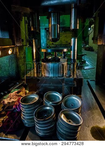 Dirty Used Low Tech Stamping Press Producing Round Aliminium Parts In Dark Environment