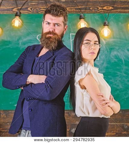 Man With Beard And Teacher In Eyeglasses Stand Back To Back, Chalkboard On Background. Lady And Hips