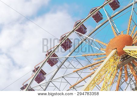 Attraction Ferris Wheel On A Background Of Blue Sky With Clouds