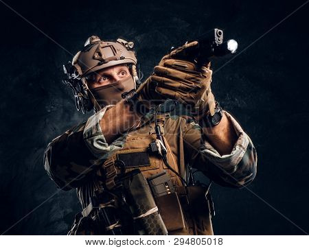 Elite Unit, Special Forces Soldier In Camouflage Uniform Holding A Gun With A Flashlight And Laims A