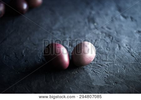 Dark Purple Eggs On A Rough Cement Background.