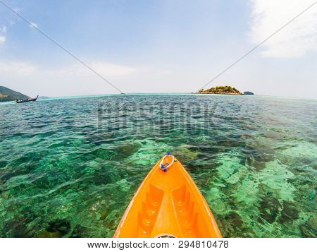 kayaking in crystal clear tropical waters - kayak heading to isolated beach in Ko Tarutao national park