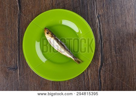 Cold Smoked Baltic Herring On An Green Plate Over A Wooden Background. Smoked Baltic Herring Smoked 