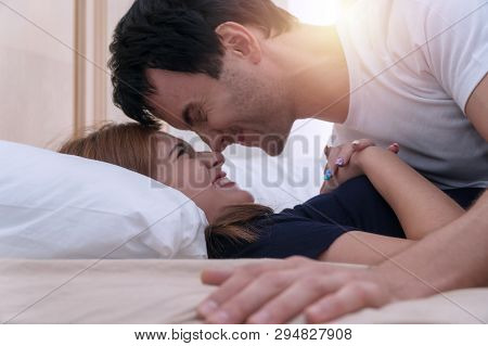 Handsome Young Man Embracing His Girlfriend Lying On The Bed. Passionate Couple Enjoying Sensual For
