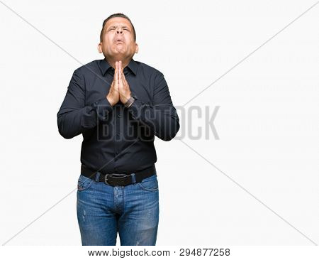 Handsome middle age arab business man over isolated background begging and praying with hands together with hope expression on face very emotional and worried. Asking for forgiveness. Religion concept