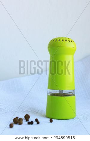 Limegreen Peppermill. Kitchen Equipment For Grinding Spices On A Linen Background. Front View.
