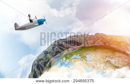 Happy Pilot Driving Small Propeller Plane On Background Of Blue Sky With Clouds. Traveling Around Th