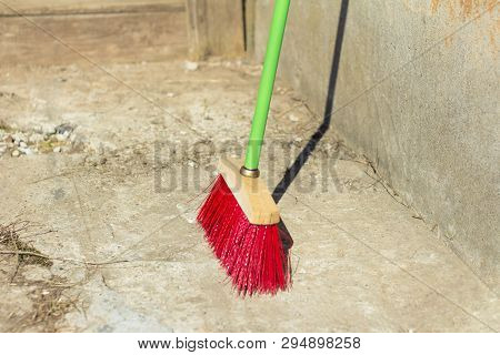 Large Broom For Cleaning The Street,standing In The Yard At The Concrete Wall On The Asphalt,the Beg