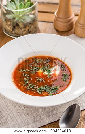 Red Beetroot Soup Borshch With Beef And Sour Cream On Wooden Table Side View