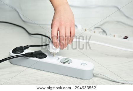 Woman Inserting Power Plug Into Extension Cord On Floor, Closeup With Space For Text. Electrician's 