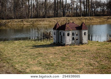 Doghouse In Shape Of A Castle On The River Bank In A Park