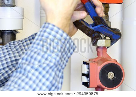 Plumber With Gripper In Hand Is Changing A Pump