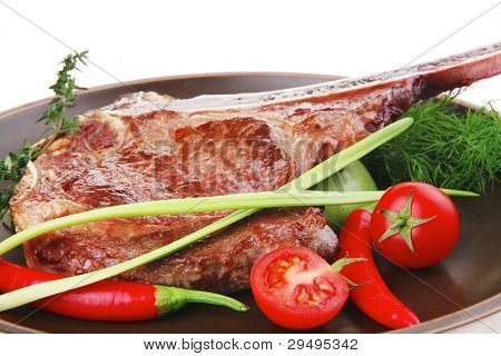 cibo di carne: manzo alla griglia di ricambio rib sul piatto scuro con timo pepe e pomodoro isolato su bianco bac