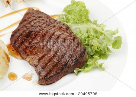 肉料理： 焼きステーキ緑レタスのサラダ ロースト玉ねぎ、白の bac に分離された皿の上に