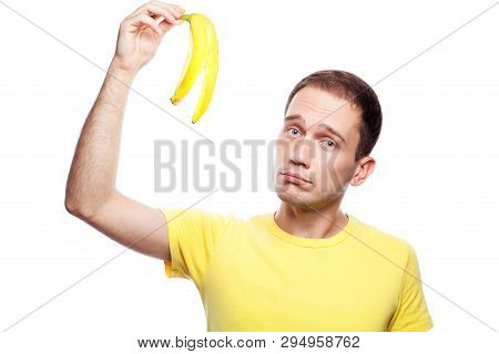 Disappointed Handsome Guy Holding Banana Skin Over White Background