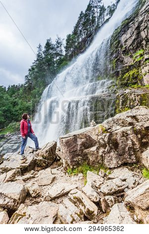 Tourist Woman At Svandalsfossen In Norway, Powerful Waterfall In Norwegian Mountains. National Touri