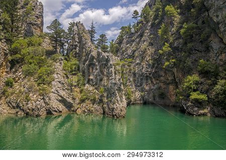 Green Lake Among Rocks. The Sky Seems Pale Compared To Water Color.