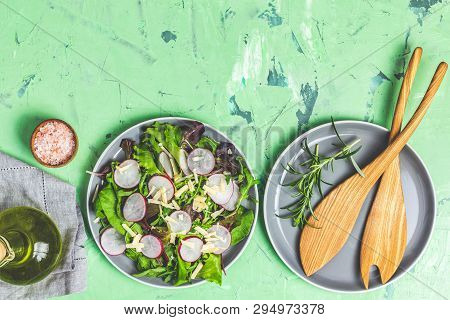 Salad With Radishes, Olive Oil,  Pink Salt, Empty Ceramic Bowl, Wooden Spoons For Salad Over Green C