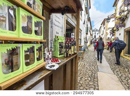 Obidos, Portugal - April 2018: Street Shops With Traditional Ginja Liqueur At The Streets Of The Old