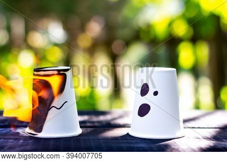 One Glass Is Burning, The Other With A Painted Worried Emotion. A Metaphor For Problems And Societys