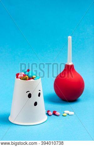 Patient With Pills - Colored Medical Pills On A Blue Background. In The Background Is A Medical Enem