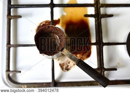 Spilled Cezve Of Coffee On Gas Stove. Dirty Gas Stove From Cezve With Coffee. Front And Background B